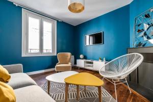 MM Suites Cathédrale في رانس: غرفة معيشة زرقاء مع أريكة وكراسي