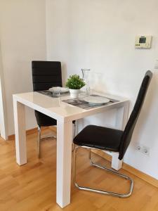 ウィーンにあるBelvedere Apartmentの白いテーブル(椅子2脚付)と白いテーブル(植物付)