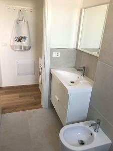 a bathroom with a sink and a toilet and a mirror at DELTA A - Piazza Marina - Vista mare in Lido di Jesolo
