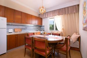 a kitchen with a table and chairs and a refrigerator at Villa Vista Al Mar in Skala Kallirachis