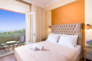 1 dormitorio con 1 cama grande y balcón en Villa Vista Al Mar, en Skala Kallirakhis