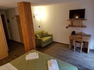 a living room with a green couch and a table at Le Nid de l'Aigle in Champoluc
