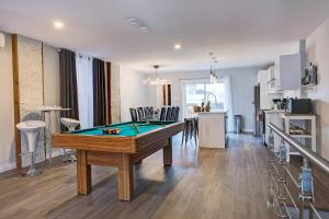 a living room with a pool table and a kitchen at Modern Townhouse with Rooftop Deck in Montreal