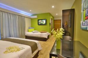 a hotel room with two beds and a tv at Eden Appartel in Koné
