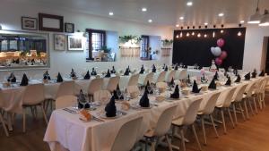 a row of tables with black hats on them in a room at El Portazgo Restaurante Hostal La Cisterniga in La Cistérniga
