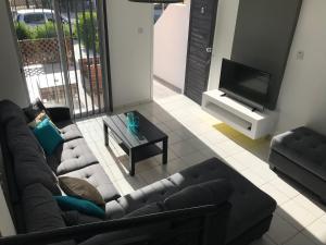 a living room with a couch and a tv at Diana Townhouse 5 in Paphos