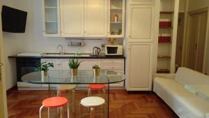 a kitchen with a glass table and two stools in a room at Varese Guest House in Rome