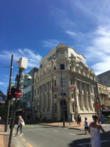 a large white building on a city street with people crossing the street at U Suites on Manners in Wellington