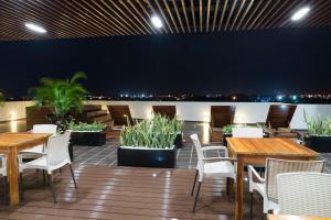 a patio with wooden tables and chairs and plants at Hotel Cinco Monteria in Montería