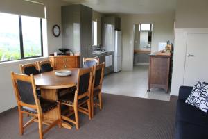 a kitchen and dining room with a wooden table and chairs at The Loft at Te Kumi Tirohanga in Te Kuiti