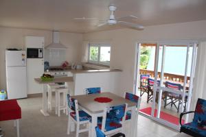 a kitchen and dining room with a table and a refrigerator at Vaiakura Holiday Homes in Rarotonga