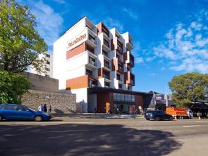 un edificio con coches estacionados frente a él en Value Suites Green Square, en Sídney