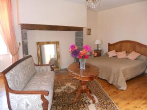 a bedroom with a bed and a table with flowers on it at Château de la Moissetie in Aurillac