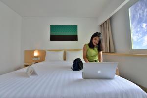 Ένα ή περισσότερα κρεβάτια σε δωμάτιο στο Whiz Prime Hotel Sudirman Pekanbaru