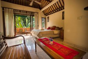 Un dormitorio con una cama y una mesa en una habitación. en Bali Asli Lodge by EPS, en Ubud