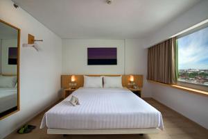 Ένα ή περισσότερα κρεβάτια σε δωμάτιο στο Whiz Prime Hotel Sudirman Pekanbaru