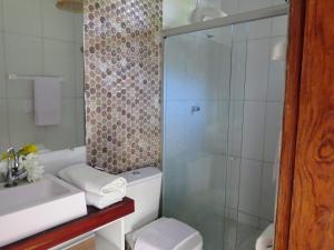 a bathroom with a shower and a toilet and a sink at Porto Mar in São Miguel dos Milagres