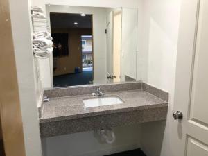 a bathroom with a sink and a mirror at Los Angeles Inn & Suites - LAX in Los Angeles +36 photos