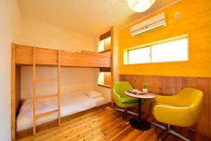 a bedroom with a bunk bed and a table and a chair at Hostel Chill Out in Osaka