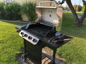 a grill sitting in the grass in a yard at Lakeshore Inn Water Front in Moses Lake