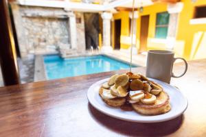 a plate of pastries on a table with a cup of coffee at Oasis Hostel in Granada