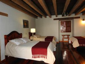 a bedroom with two beds in a room at Hotel Santa Clara in San Cristóbal de Las Casas