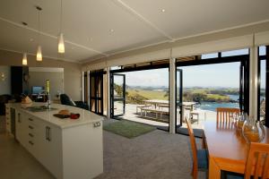 a kitchen and dining room with a view of the ocean at Cliff House in Whangarei Heads
