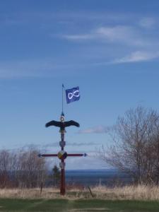 um mastro com uma bandeira sobre ele em um campo em Motel la Maison de Travers em Baie-Sainte-Catherine