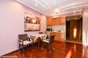 a kitchen with a dining room table and chairs at Menios Apartments and Studios in Nea Kalikratia
