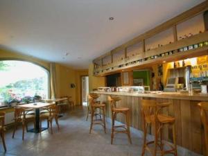 a restaurant with a bar with chairs and tables at Hotel Cosgaya in Cosgaya