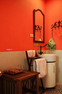 baño con paredes de color naranja, lavabo y mesa en Raid Garden Boutique Hotel, en Magong