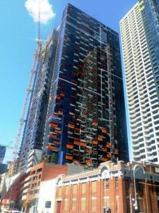 a tall building is under construction in a city at Upper West Side - Madison in Melbourne