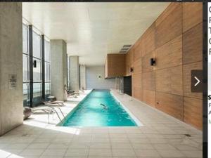 a swimming pool in a building with a person in it at Upper West Side - Madison in Melbourne
