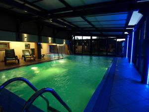 a swimming pool with green water in a building at Avena in Niechorze