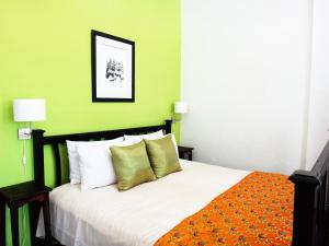 una camera da letto con un grande letto con pareti verdi di The Apsara a Luang Prabang
