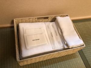 Una cesta con toallas plegadas blancas. en Guest House En, en Nara