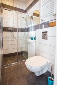 a bathroom with a toilet and a glass shower at Sopot City Apartment in Sopot