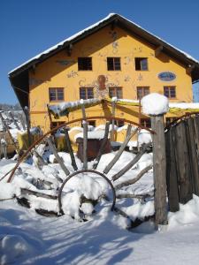 uma casa amarela na neve com neve em Schiff Bihlerdorf - Hostel em Bihlerdorf