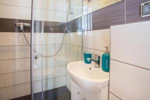 a bathroom with a sink and a shower at Sopot City Apartment in Sopot