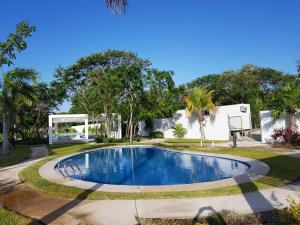 a swimming pool in a yard with trees at Casa acogedora Rivera Maya in Playa del Carmen
