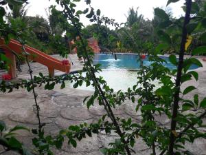 a swimming pool with a slide in a resort at Relaxing Garden Resort in Sara