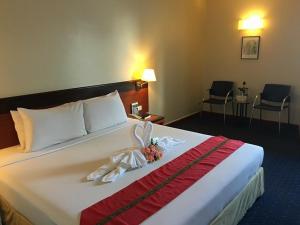 una camera d'albergo con un grande letto fiorito di Hatyai Golden Crown Hotel a Hat Yai