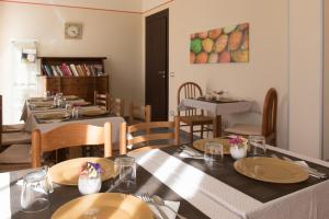 a dining room with tables and chairs with plates on them at B&B Cafisu in Paceco
