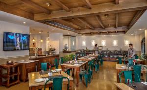 a restaurant with wooden tables and green chairs at Nepali Ghar Hotel in Kathmandu