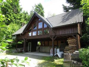 ein großes Holzhaus mit vielen Fenstern in der Unterkunft Ferienhaus im Grünen - NEU mit E-Auto Ladesäule in Morsbach