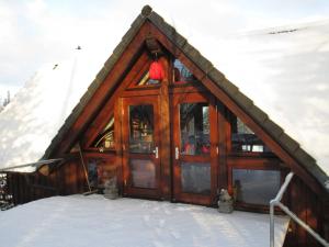 a house with a glass door in the snow at Ferienhaus im Grünen - NEU mit E-Auto Ladesäule in Morsbach +18 photos