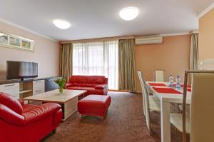 a living room with a red couch and a table at Teplice Plaza in Teplice