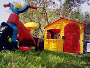 a toy truck and a play house in the grass at Dimos Bungalows in Paleo Tsifliki