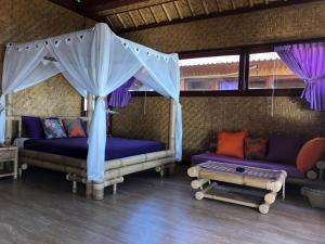 a living room with two couches and a canopy at Good Karma Bungalows in Amed