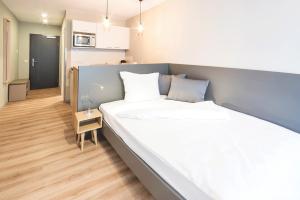 Un dormitorio con una cama grande en una habitación. en City Studios, en Heidenheim an der Brenz 20 fotos más